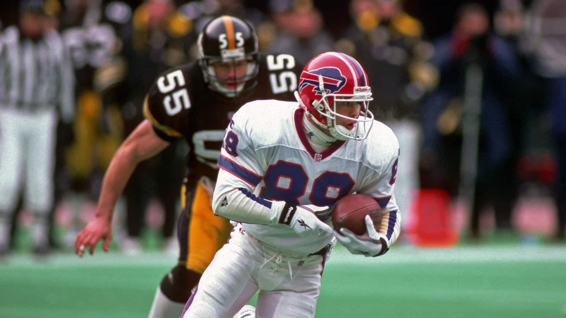 PITTSBURGH, PA - JANUARY 6: Punt returner Steve Tasker #89 of the Buffalo Bills is pursued by linebacker Jerry Olsavsky #55 of the Pittsburgh Steelers as he runs with the football during a playoff game at Three Rivers Stadium on January 6, 1996 in Pittsburgh, Pennsylvania. The Steelers defeated the Bills 40-21.