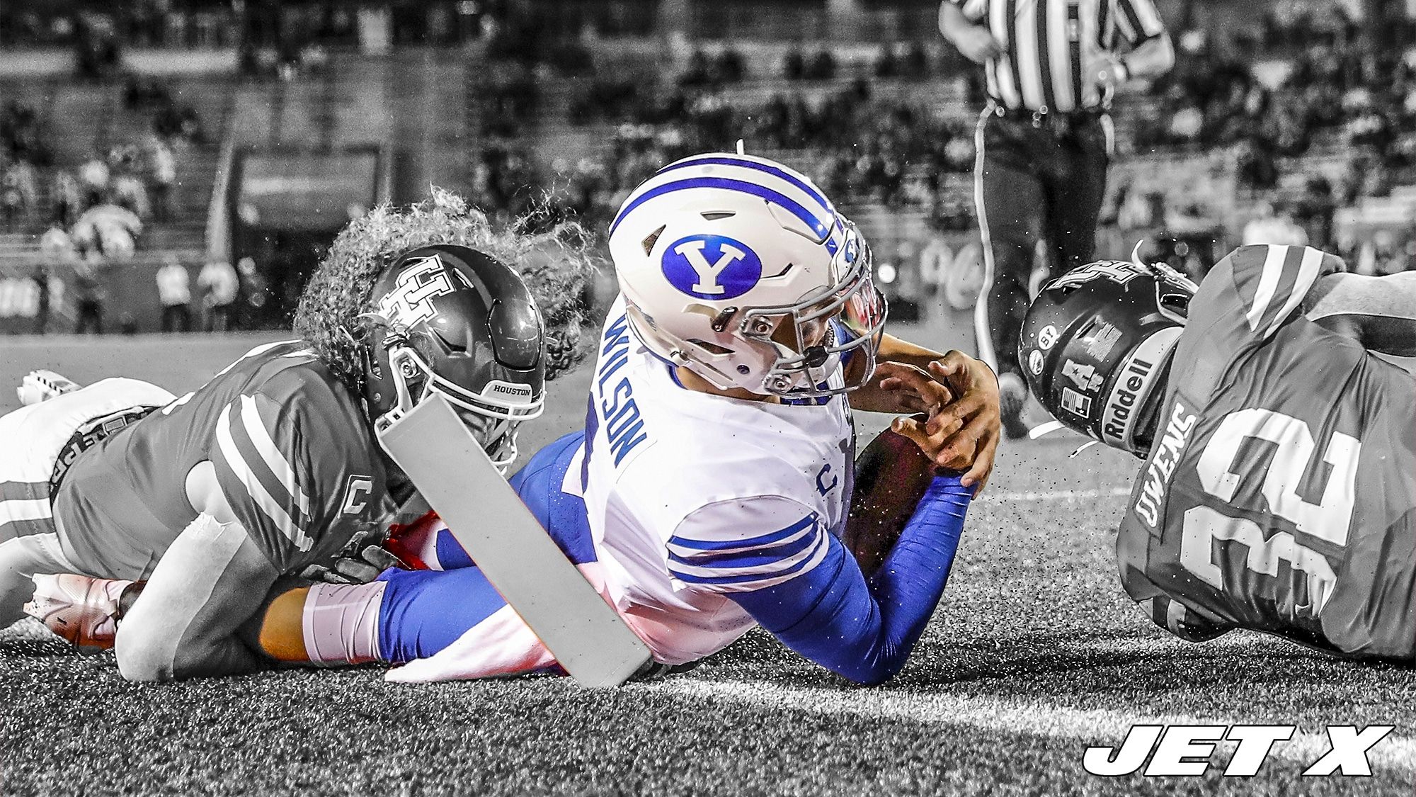 HOUSTON, TEXAS - OCTOBER 16: Zach Wilson #1 of the BYU Cougars is tackled near the goal line by Grant Stuard #0 of the Houston Cougars and Gervarrius Owens #32 in the first half at TDECU Stadium on October 16, 2020 in Houston, Texas.