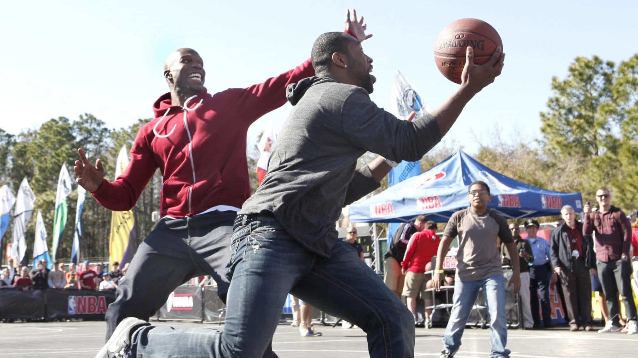 LAKE BUENA VISTA, FL - FEBRUARY 28: In this handout photo provided by Disney, New York Jets cornerback Darrelle Revis (right) drives to the basket as Cincinnati Bengals wide receiver Chad Ochocinco (left) defends against him during an impromptu game of "two-on-two" basketball at Disney's Hollywood Studios theme park on February 28, 2010 in Lake Buena Vista, Florida. A basketball court was set up outdoors in the Walt Disney World theme park this weekend as part of "ESPN The Weekend," an annual sports fan festival. Ochocinco and Revis, both Pro Bowl selections from the AFC this season, chose fans from the audience as their teammates. Ochocinco teamed with Jason Moorman (far right, background), age 12, from Orlando, Florida, and Revis teamed with Bailey High (not pictured), age 14, from Fort Cove, Pennsylvania. In the end, "Team Revis" defeated "Team Ochocinco" by score of 7-5 in the halfcourt contest.
