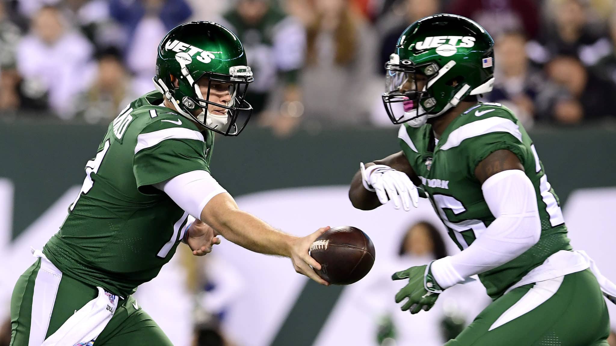 EAST RUTHERFORD, NEW JERSEY - OCTOBER 21: Sam Darnold #14 hands the ball off to Le'Veon Bell #26 of the New York Jets against the New England Patriots during the first half at MetLife Stadium on October 21, 2019 in East Rutherford, New Jersey.