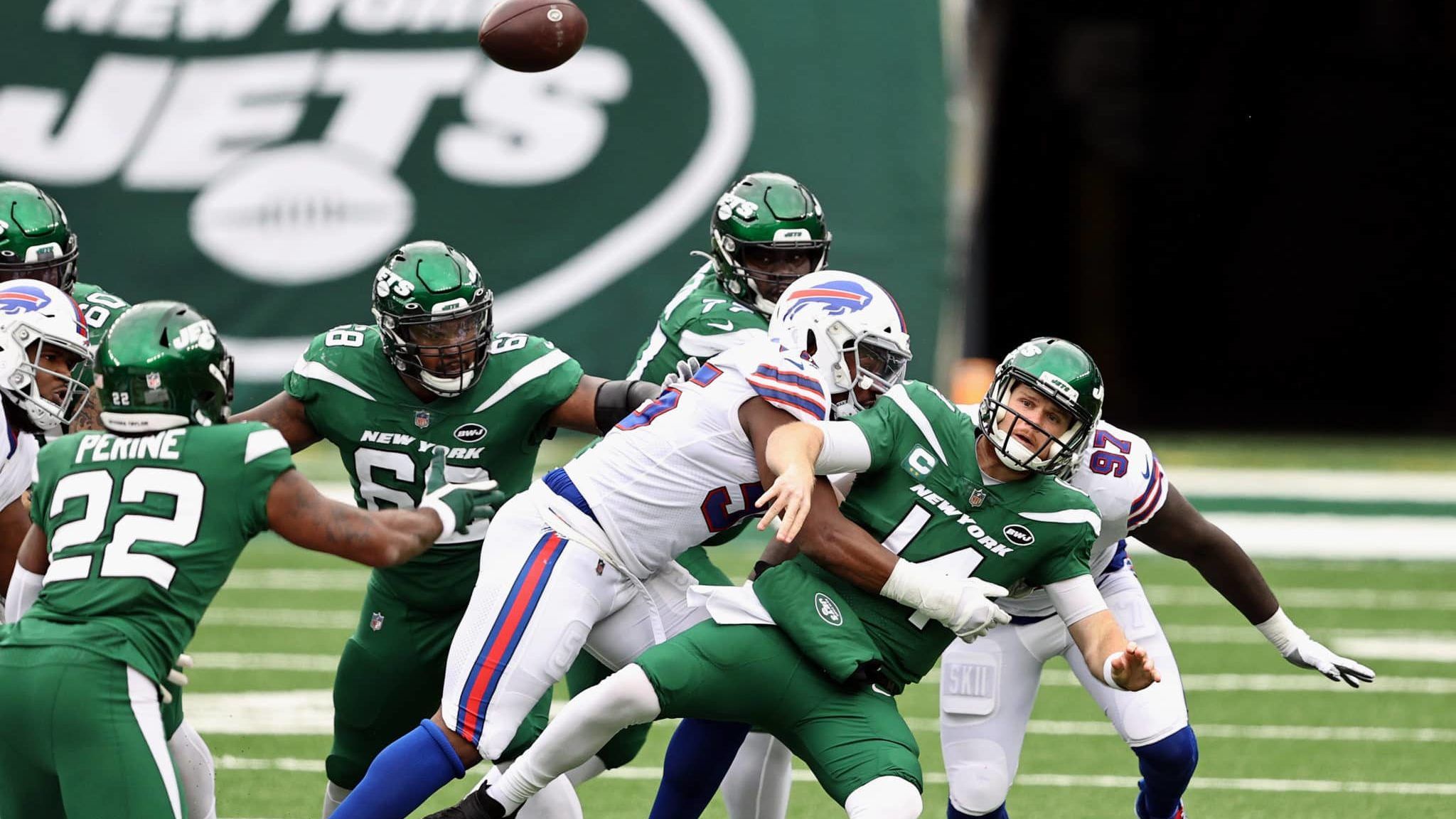 EAST RUTHERFORD, NEW JERSEY - OCTOBER 25: Quarterback Sam Darnold #14 of the New York Jets throws an incomplete pass as he is tackled by Jerry Hughes #55 of the Buffalo Bills in the second quarter of the game at MetLife Stadium on October 25, 2020 in East Rutherford, New Jersey.