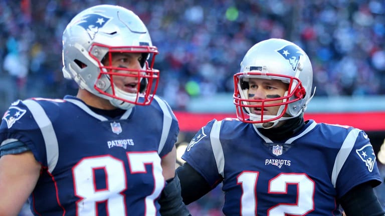 FOXBOROUGH, MASSACHUSETTS - JANUARY 13: Tom Brady #12 of the New England Patriots and Rob Gronkowski #87 react during the second quarter in the AFC Divisional Playoff Game against the Los Angeles Chargers at Gillette Stadium on January 13, 2019 in Foxborough, Massachusetts.