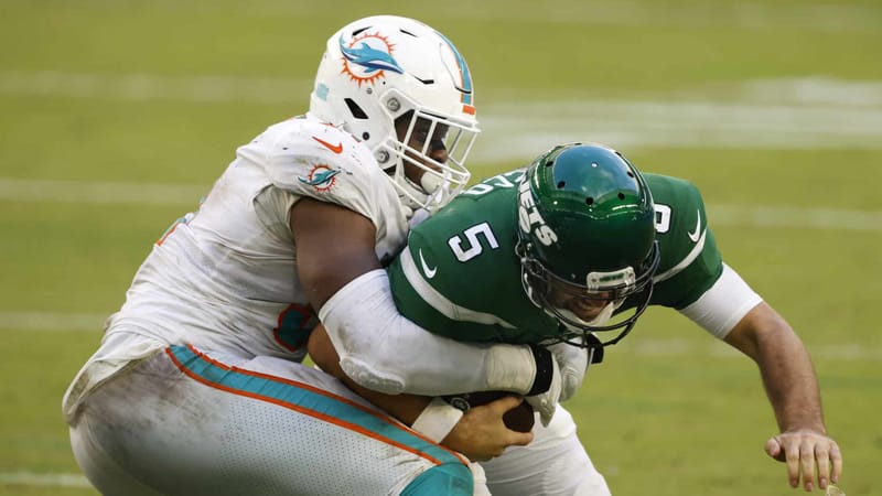 MIAMI GARDENS, FLORIDA - OCTOBER 18: Emmanuel Ogbah #91 of the Miami Dolphins tackles quarterback Joe Flacco #5 of the New York Jets for the sack during the second half of their game at Hard Rock Stadium on October 18, 2020 in Miami Gardens, Florida.