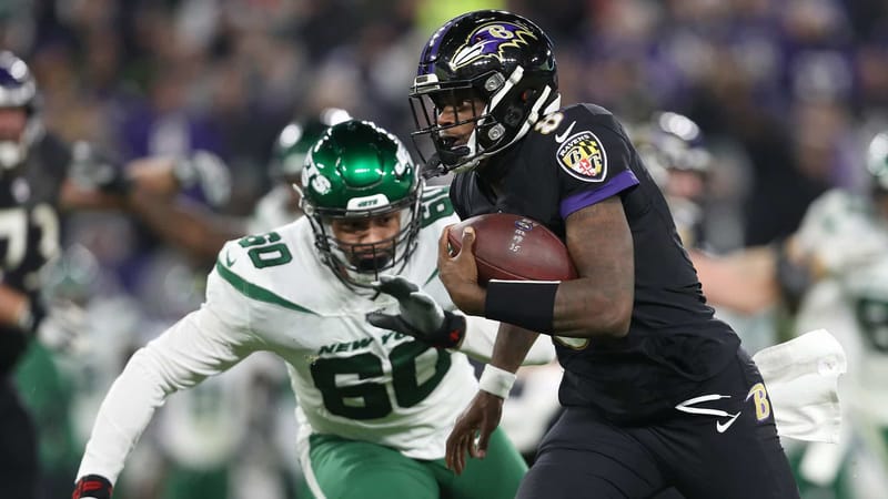 BALTIMORE, MARYLAND - DECEMBER 12: Quarterback Lamar Jackson #8 of the Baltimore Ravens carries the ball against defensive end Jordan Willis #60 of the New York Jets during the game at M&T Bank Stadium on December 12, 2019 in Baltimore, Maryland.