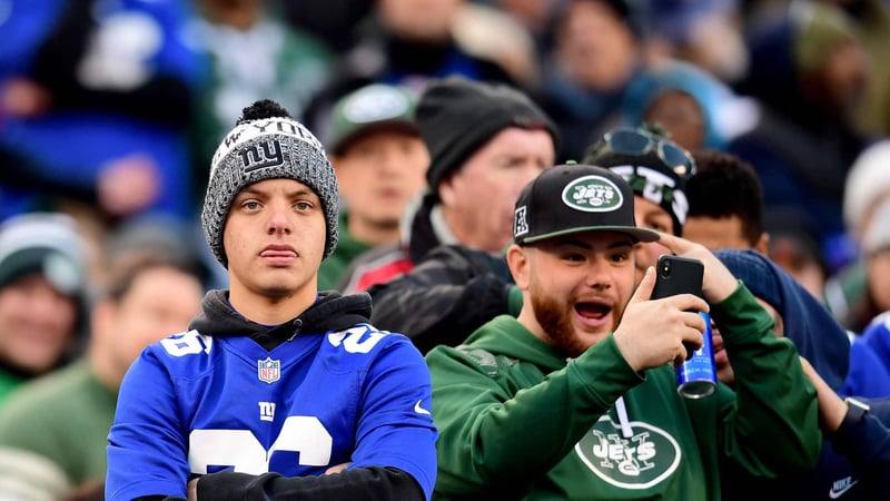 EAST RUTHERFORD, NEW JERSEY - NOVEMBER 10: A New York Jets fan celebrates as a New York Giants looks on during their game at MetLife Stadium on November 10, 2019 in East Rutherford, New Jersey. The Jets beat the Giants 34-27.