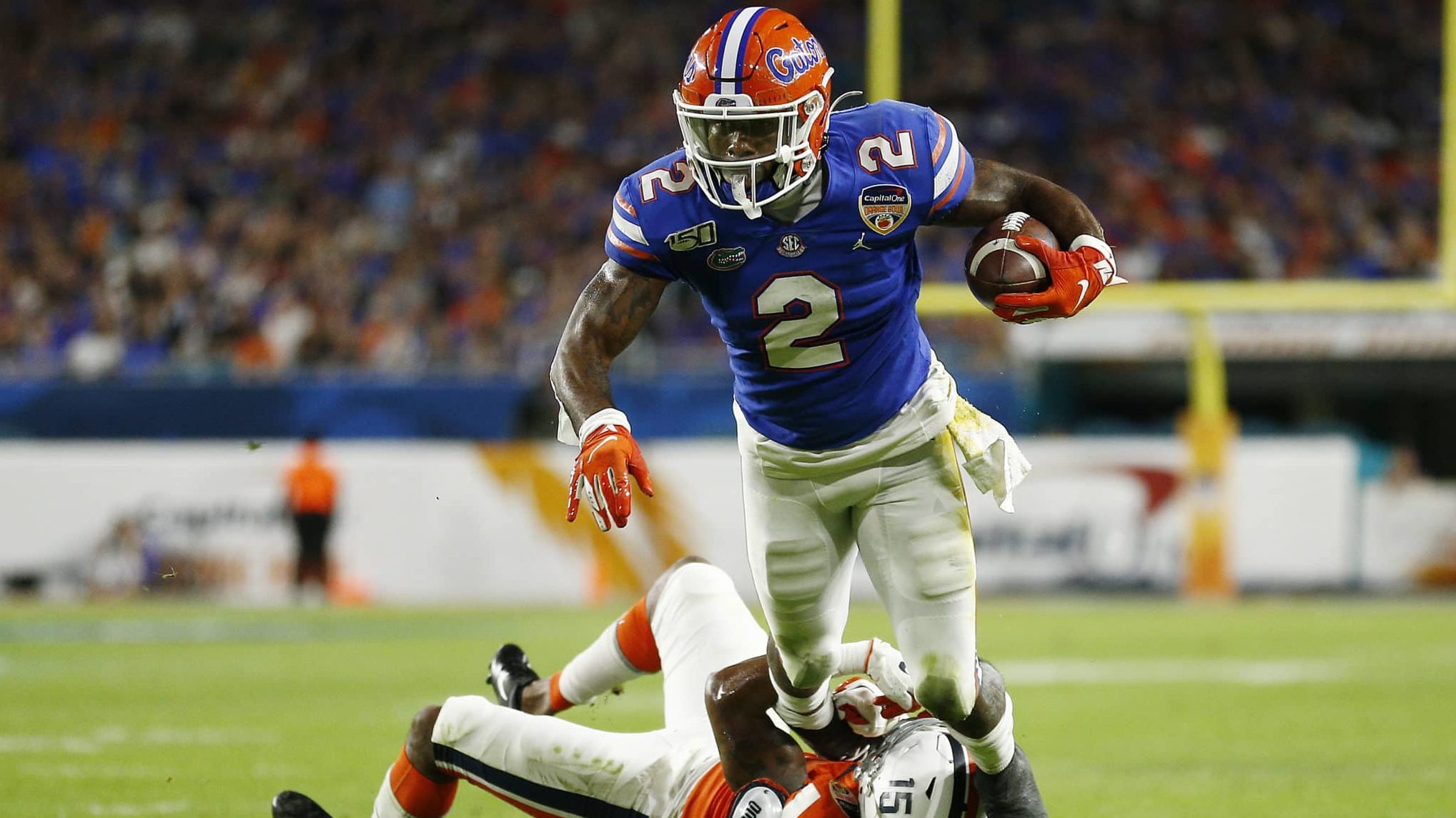 MIAMI, FLORIDA - DECEMBER 30: Lamical Perine #2 of the Florida Gators breaks a tackle from De'Vante Cross #15 of the Virginia Cavaliers during the first half of the Capital One Orange Bowl at Hard Rock Stadium on December 30, 2019 in Miami, Florida.