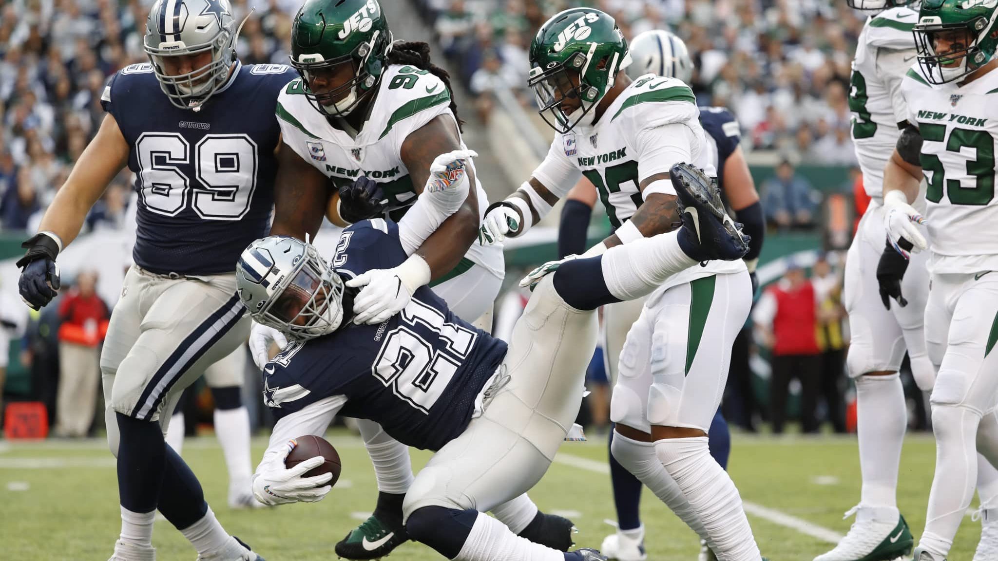 EAST RUTHERFORD, NEW JERSEY - OCTOBER 13: Ezekiel Elliott #21 of the Dallas Cowboys is brought down by Steve McLendon #99 and Jamal Adams #33 of the New York Jets during the second quarter game at MetLife Stadium on October 13, 2019 in East Rutherford, New Jersey.