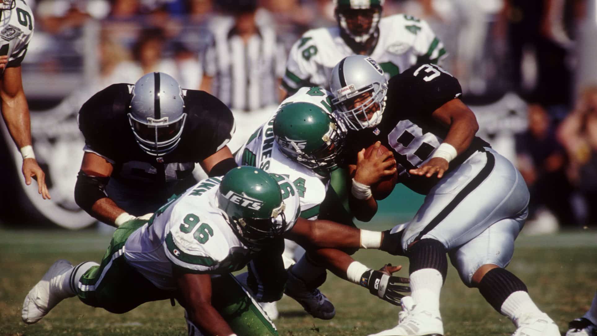 The Los Angeles Raiders Nick Bell is hit by Mark Gunn (96) and Marvin Jones (54) of the New York Jets.