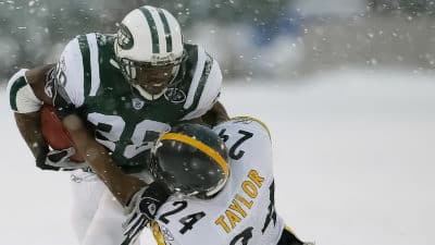 UNITED STATES - DECEMBER 14: The New York Jets' Curtis Martin tries to break free of a tackle by the Pittsburgh Steelers' Ike Taylor on a snowy field in the first half at Giants Stadium. The Jets triumphed, 6-0, on two field goals.