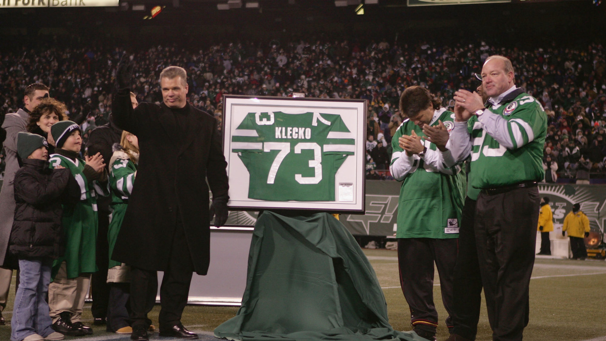 EAST RUTHERFORD, NJ - DECEMBER 26: Former player Joe Klecko (L) of the New York Jets gets his jersey retired during halftime against the New England Patriots on December 26, 2004 at Giants Stadium in East Rutherford, New Jersey. The Patriots defeated the Jets 23-7.